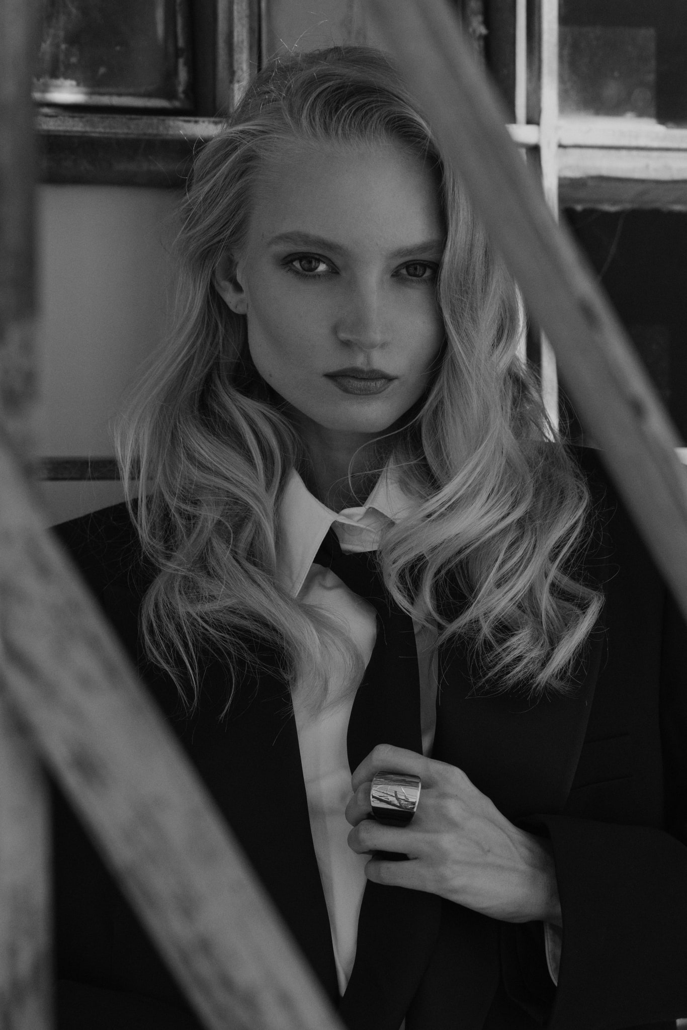 Nikita Lauffer in a suit and tie beside a window frame